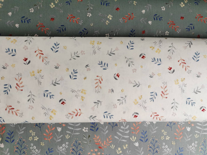 Könnte beinhalten: Zwei Stoffstücke mit weißem und grünem Hintergrund. Beide Stoffe haben ein kleines Blumenmuster mit grauen, roten und gelben Blüten.